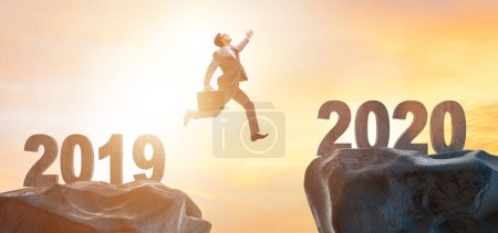 Téléchargez les photos : L'homme d'affaires sautant de l'année 2019 à 2020 - en image libre de droit