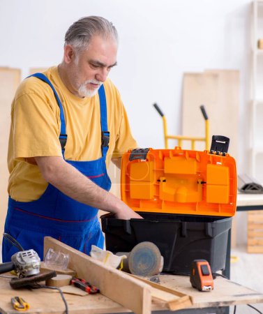 Photo for The old male carpenter working in workshop - Royalty Free Image