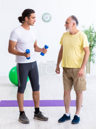 Téléchargez les photos : Le vieil homme faisant des exercices à l'intérieur - en image libre de droit