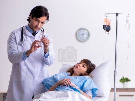 Photo for The male doctor visiting female patient in ward - Royalty Free Image