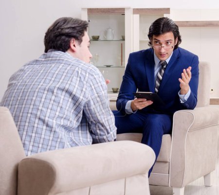 Foto de Paciente masculino joven discutiendo con psicólogo problemas personales - Imagen libre de derechos
