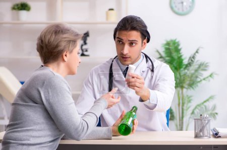Photo for The female alcoholic visiting young male doctor - Royalty Free Image