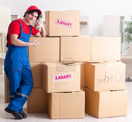 Photo for The young male contractor with boxes working indoors - Royalty Free Image