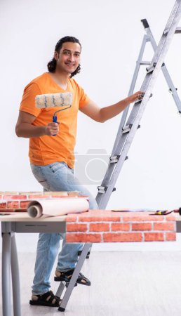 Téléchargez les photos : Le jeune homme entrepreneur en rénovation à la maison - en image libre de droit