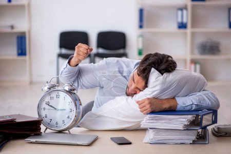 Téléchargez les photos : Jeune homme d'affaires employé dans un concept de sommeil excessif - en image libre de droit