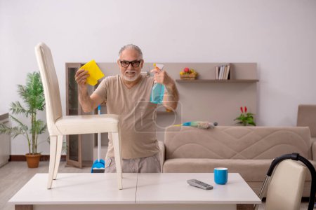 Téléchargez les photos : Homme âgé faisant des travaux ménagers à la maison - en image libre de droit