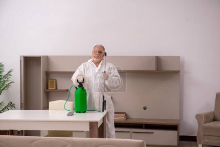 Foto de Viejo contratista haciendo control de plagas en casa - Imagen libre de derechos
