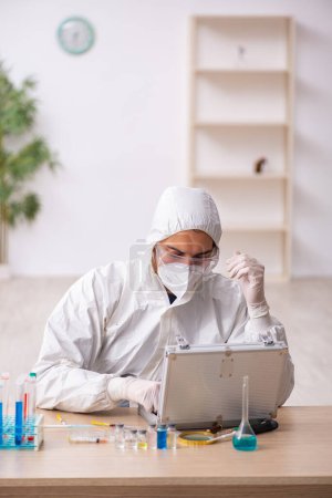 Téléchargez les photos : Jeune chimiste travaillant au laboratoire pendant la pandémie - en image libre de droit