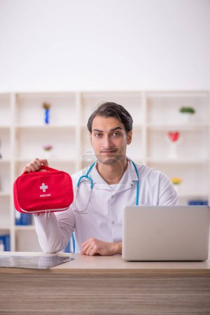 Foto de Joven médico paramédico sosteniendo bolsa de primeros auxilios - Imagen libre de derechos