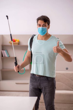 Foto de Joven contratista haciendo control de plagas en casa - Imagen libre de derechos