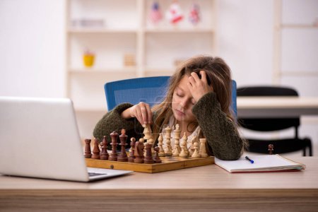 Téléchargez les photos : Jeune petite fille jouant aux échecs à la maison - en image libre de droit