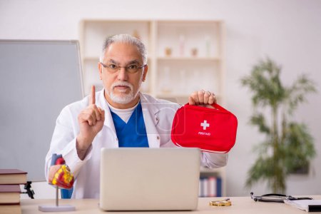 Photo for Old doctor paramedic holding first aid bag - Royalty Free Image