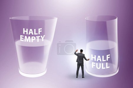 Foto de Empresario en el medio vacío medio lleno concepto de vidrio - Imagen libre de derechos