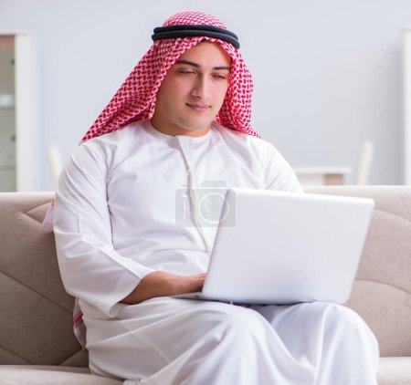 Téléchargez les photos : L'homme d'affaires arabe travaillant assis sur le canapé - en image libre de droit