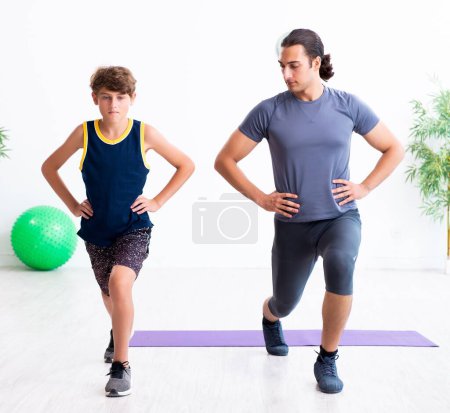 Photo for The young father and his son doing exercises - Royalty Free Image
