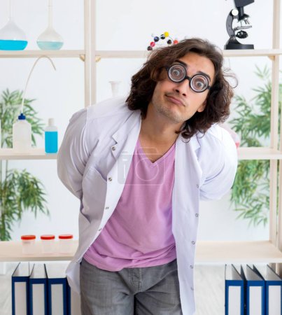 Téléchargez les photos : Le chimiste masculin drôle travaillant dans le laboratoire - en image libre de droit