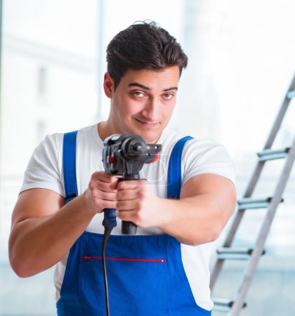 Photo for The young worker with hand drill - Royalty Free Image