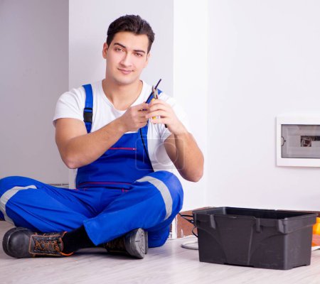 Foto de El hombre haciendo reparaciones eléctricas en casa - Imagen libre de derechos
