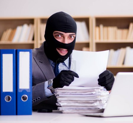 Photo for The criminal businessman with balaclava in office - Royalty Free Image