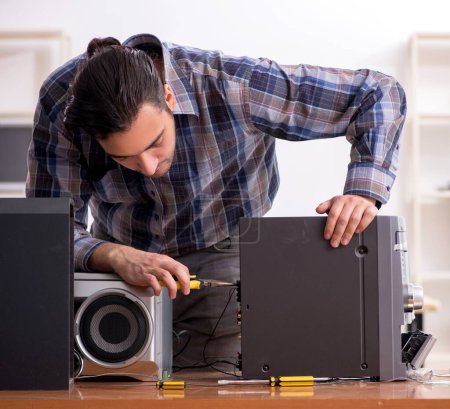 Photo for The young engineer repairing musical hi-fi system - Royalty Free Image