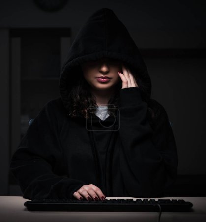Foto de La hacker mujer piratería firewall de seguridad tarde en la oficina - Imagen libre de derechos