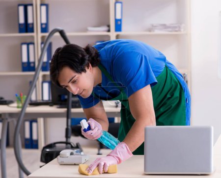 Photo for The male handsome professional cleaner working in the office - Royalty Free Image