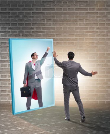 Téléchargez les photos : L'homme d'affaires se voit dans le miroir comme un super-héros - en image libre de droit