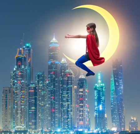 Foto de El niño superhéroe sentado en la luna creciente - Imagen libre de derechos