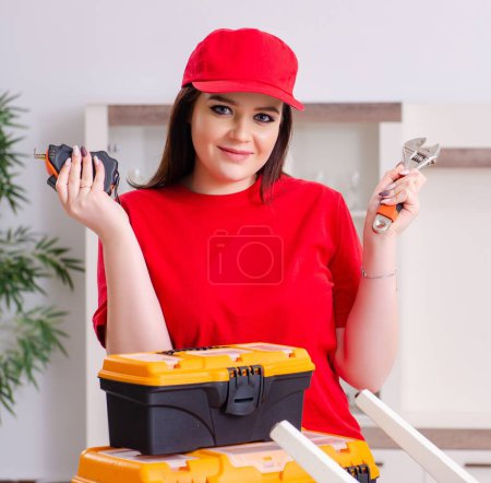 Photo for The young woman repairing chair at home - Royalty Free Image