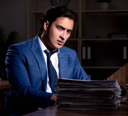 Photo for The young male employee working night in the office - Royalty Free Image