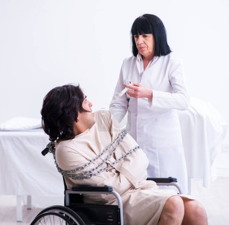 Foto de La anciana psiquiatra visitando a un joven paciente masculino - Imagen libre de derechos