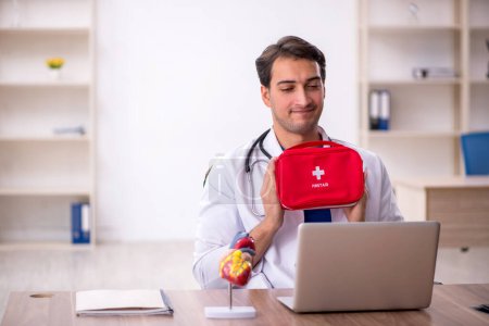Photo for Young male doctor holding first aid bag - Royalty Free Image