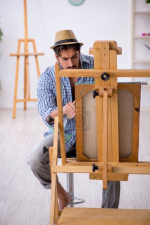 Téléchargez les photos : Jeune homme appréciant la peinture à la maison - en image libre de droit