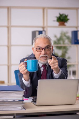 Téléchargez les photos : Vieil homme d'affaires employé boire du café pendant la pause - en image libre de droit