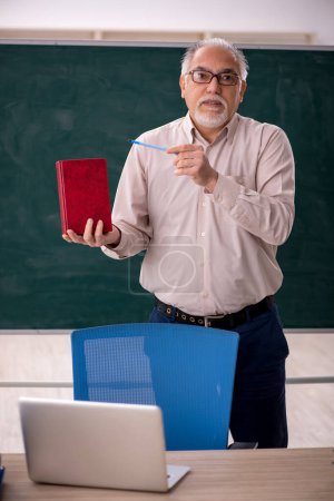 Téléchargez les photos : Vieil enseignant devant le panneau vert - en image libre de droit