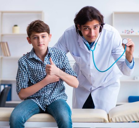 Photo for The male doctor examining boy by stethoscope - Royalty Free Image