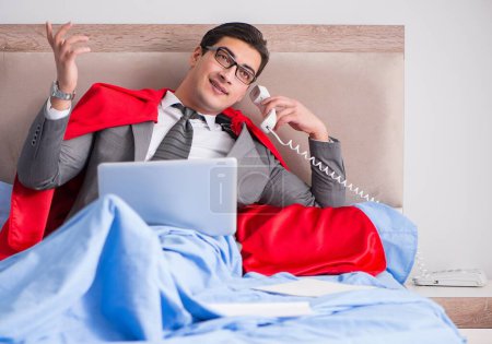Téléchargez les photos : La femme d'affaires super héros travaillant au lit - en image libre de droit