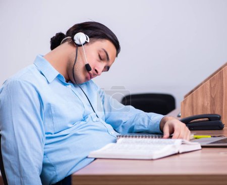 Foto de El operador del centro de llamadas que trabaja en su escritorio - Imagen libre de derechos
