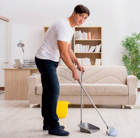 Photo for The man cleaning home with broom - Royalty Free Image