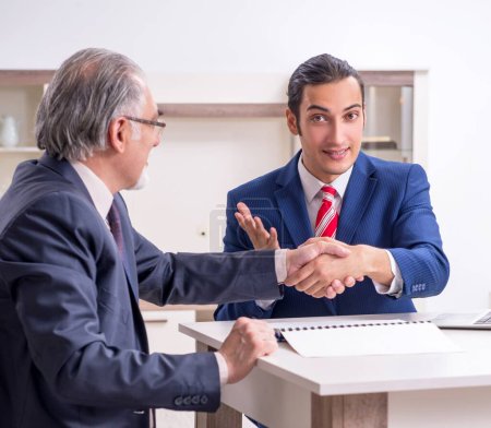 Téléchargez les photos : Les deux hommes d'affaires discutant affaires au bureau - en image libre de droit