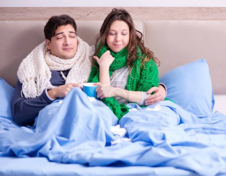 Téléchargez les photos : La femme malade et le mari au lit à la maison - en image libre de droit
