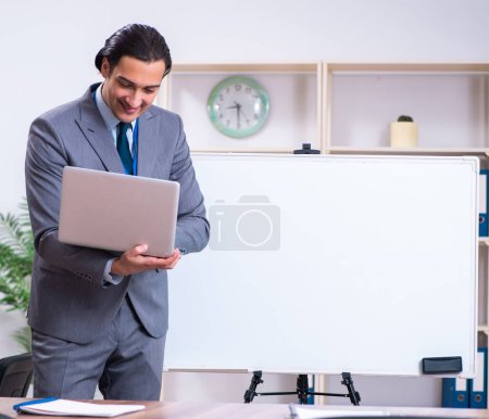 Photo for The young businessman standing in front of white board - Royalty Free Image