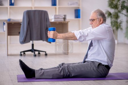 Téléchargez les photos : Ancien employé faisant des exercices sportifs pendant la pause - en image libre de droit