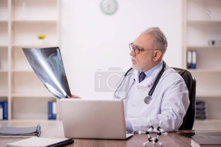 Téléchargez les photos : Vieux médecin radiologue travaillant à l'hôpital - en image libre de droit