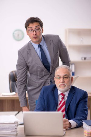 Photo for Two male colleagues sitting at workplace - Royalty Free Image