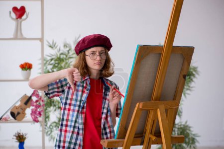 Photo for Young female student enjoying painting at home - Royalty Free Image