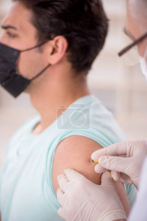 Photo for Young patient visiting old male doctor in vaccination concept - Royalty Free Image