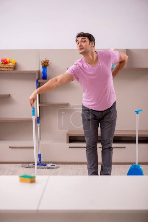 Foto de Joven contratista limpiando la casa - Imagen libre de derechos