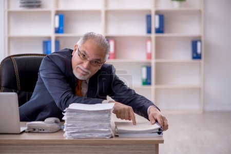 Foto de Viejo empleado de negocios descontento con el trabajo excesivo en la oficina - Imagen libre de derechos