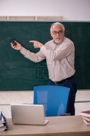 Photo for Old teacher in front of green board - Royalty Free Image